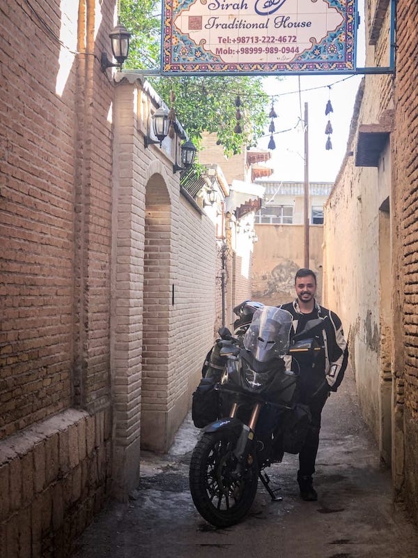 Tobi with his motorbike in a narrow alley in Iran